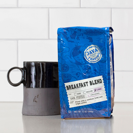 Bag of 12 ounce Breakfast Blend coffee on a kitchen counter with black and gray mug