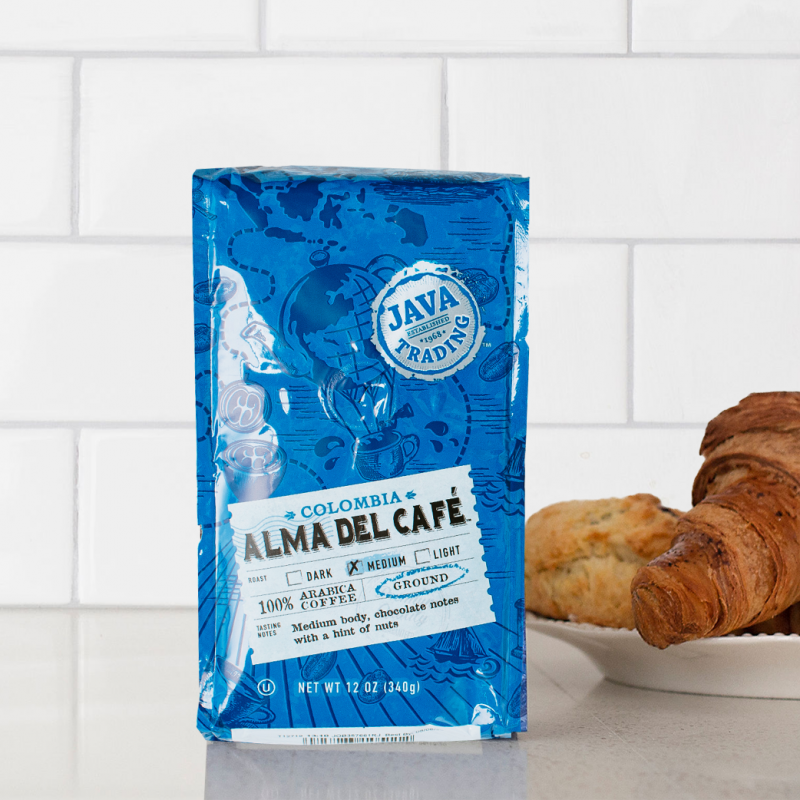 Bag of 12 ounce of Colombia Alma Del Cafe coffee on a kitchen counter with croissants
