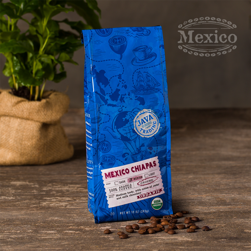 Bag of 10 ounce of Organic Mexico Chiapas coffee on a wooden table with coffee plant in burlap bag