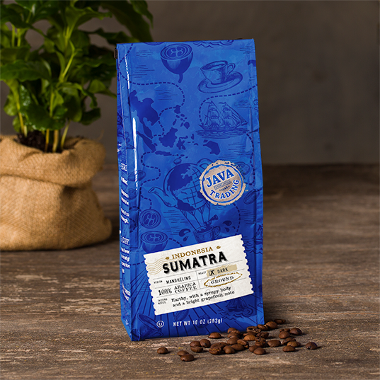 Blue bag of Indonesia Sumatra Coffee Bag, dark roast, ground, 10 ounces on a wooden table with plant